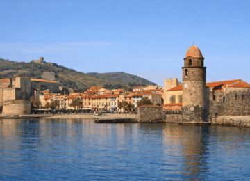 Vue de Collioure au printemps avec mer calme et clocher.